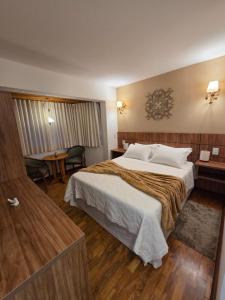 a hotel room with a large bed and a table at The Winter Mountain Hotel in Monte Verde
