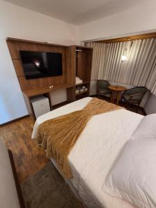 a hotel room with a bed and a flat screen tv at The Winter Mountain Hotel in Monte Verde +43 photos