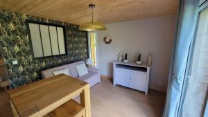 a living room with a table and a dining room at le verger des Sy Pommier in Picauville