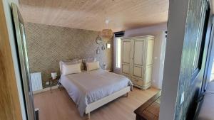 a bedroom with a bed with white sheets and pillows at le verger des Sy Pommier in Picauville