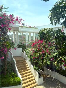 eine Treppe in einem Garten mit rosa Blüten in der Unterkunft The Lead Hotel in Freetown