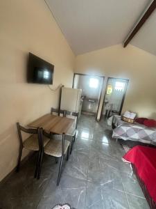 a room with a table and chairs and a refrigerator at Chalé do coiote 2 in São Roque de Minas +9 photos