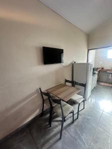a room with a table and two chairs and a tv at Chalé do coiote 2 in São Roque de Minas