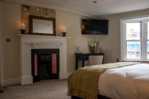 a bedroom with a fireplace and a bed and a tv at The Marlborough Inn in Marlborough