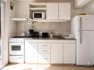 a kitchen with white cabinets and a white refrigerator at Amutuy Bariloche in San Carlos de Bariloche +20 photos