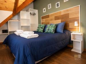 a bedroom with a blue bed with towels on it at Amutuy Bariloche in San Carlos de Bariloche