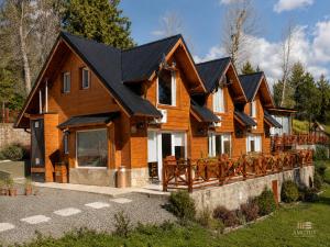 a large wooden house with a black roof at Amutuy Bariloche in San Carlos de Bariloche
