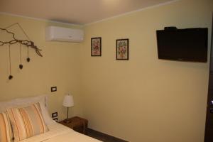 a bedroom with a bed and a tv on the wall at Appartamento B&B La Meta in Fisciano