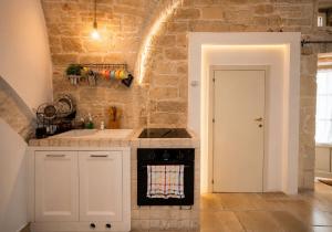 a kitchen with white cabinets and a stove top oven at Martine Dimore Storiche di Puglia in Martina Franca +18 photos