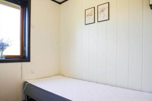 a bed in a room with two pictures on the wall at 14250-Grevinge-Hybenvaenget-9 in Grevinge