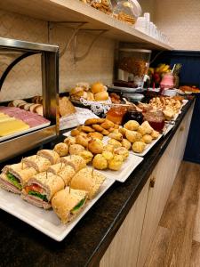 a buffet line with sandwiches and pastries and other foods at Pousada Jasmim in Gramado +20 photos