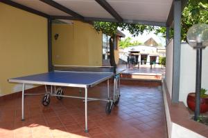 a ping pong table sitting on a patio at Casa RUDOM in Aci SantʼAntonio