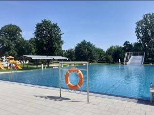 a swimming pool with an orange life ring in the middle at Naturparadies an der Saale in Könnern