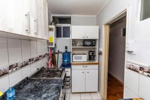 a kitchen with white cabinets and a stove at Departamento Freire in Valparaíso