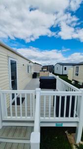 a deck with a white railing and houses at The Pastures 29 Caravan in Tattershall