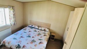 a small bedroom with a bed in a room with a window at The Pastures 29 Caravan in Tattershall +21 photos