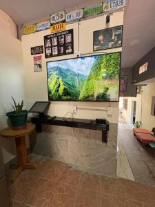 a large flat screen tv on a wall in a room at Hostal Charlotte in La Unión