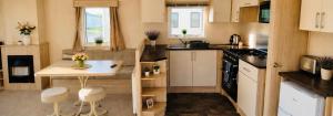 a small kitchen with a table and chairs in a caravan at The Pastures 29 Caravan in Tattershall