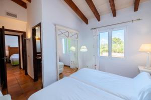 a white bedroom with a bed and a window at Villas Finesse By MENORCARENTALS in Son Bou +111 photos
