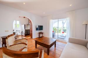 a living room with a couch and a table at Villas Finesse By MENORCARENTALS in Son Bou