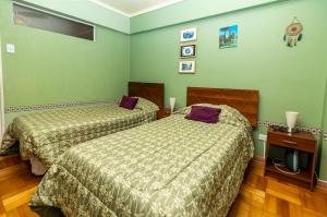 two beds in a room with green walls at Departamento Freire in Valparaíso +27 photos
