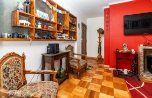 a living room with a red wall and two chairs at Departamento Freire in Valparaíso
