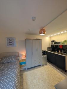 a bedroom with a bed and a sink and a kitchen at Private Studio Anex in Sherborne Saint John