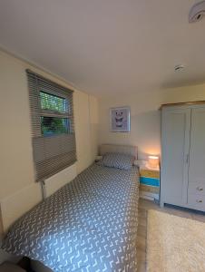 a bedroom with a bed and a dresser and a window at Private Studio Anex in Sherborne Saint John
