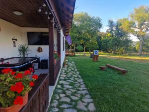 a garden next to a house with a lawn at Pensiunea Cocoș in Spulber +14 photos