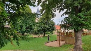 a person standing in a park with a playground at Naturparadies an der Saale in Könnern