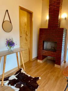 a living room with a brick fireplace and a table at Casa Araucária in Cunha