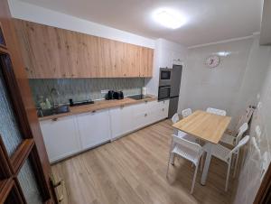a kitchen with a wooden table and a table and chairs at Mosquera House in Arzúa