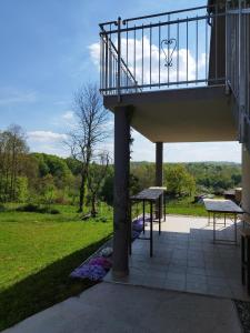 a balcony of a house with a table and benches at Apartmani Bele breze in Adlešiči