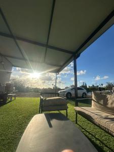 a table and chairs under a tent with a car at Quiet spot in Qiryat Ata
