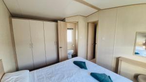 a small bedroom with a bed and a toilet at The Pastures 29 Caravan in Tattershall