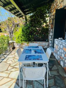 a white table and chairs on a patio at Polyxeni villa - Neo Klima in Skopelos Town