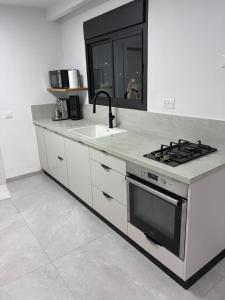a kitchen with a sink and a stove at Quiet spot in Qiryat Ata