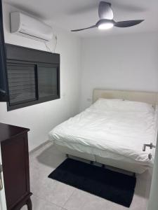 a bedroom with a bed with a ceiling fan at Quiet spot in Qiryat Ata