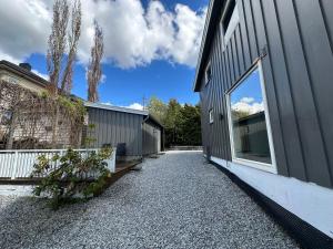 a house with a gravel driveway next to a building at Flott sommerhus midt i Lillehammer sentrum in Lillehammer
