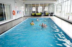 a group of people swimming in a swimming pool at Surf Shack Caravan - Lyons Winkups in Kinmel Bay