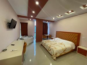 a bedroom with a bed and a sink in it at Hotel KTHELLA in Rrëshen