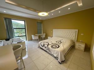 a bedroom with a bed and a desk and a sink at Hotel KTHELLA in Rrëshen +29 photos