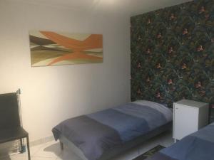 ein Schlafzimmer mit einem Bett und einem Gemälde an der Wand in der Unterkunft APPARTEMENT 3 LITS Parking Proche Rouen Dock in Canteleu