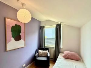a bedroom with a bed and a chair and a window at 20432-Samso-Klintevej-6 in Ballen