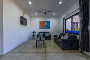 a living room with two couches and a tv at Las Palmas Hotel - Cerritos Beach in El Pescadero