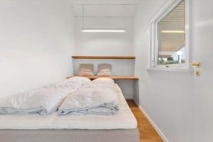 a small bedroom with a bed and a window at 84265-Ega-Strandvangsvej-27 in Skæring