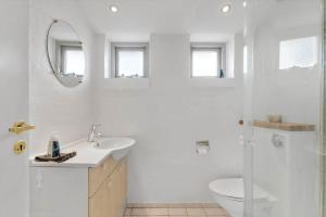 a white bathroom with a toilet and a sink at 84265-Ega-Strandvangsvej-27 in Skæring +12 photos