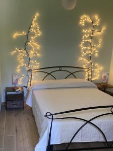 a bedroom with a bed with christmas lights on the wall at Sweet Home Spalmatore in Carloforte