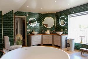 a bathroom with a tub and two sinks and mirrors at GOT698-Laerbro-Rute-Sofiero-133 in Lärbro +24 photos