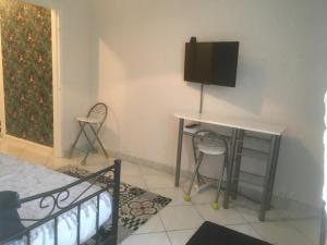 ein Zimmer mit einem Schreibtisch und einem Fernseher an der Wand in der Unterkunft APPARTEMENT 3 LITS Parking Proche Rouen Dock in Canteleu